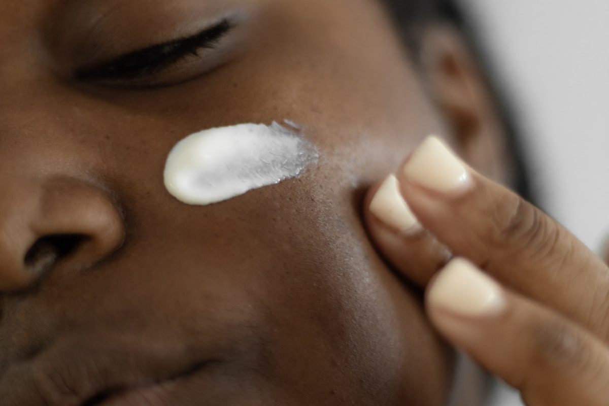 Black woman applying a professional skincare cream