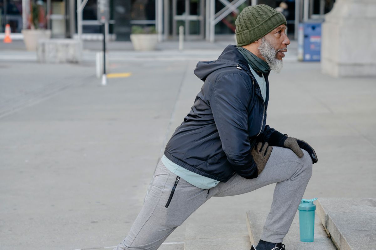 Older Black man stretching during an accessible wellness session